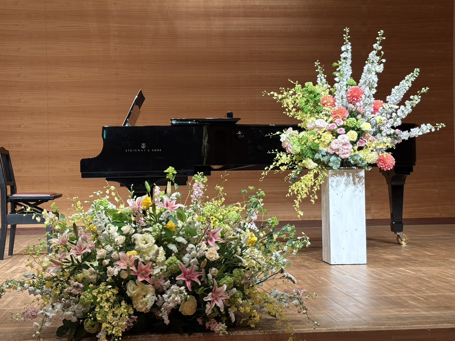 発表会・演奏会の会場。グランドピアノと花のアレンジメント（妹尾美沙バイオリン教室）